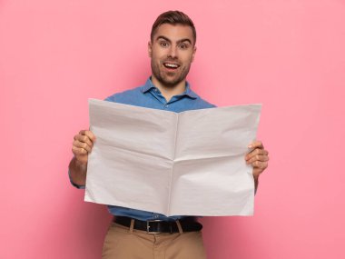 Stüdyoda pembe arka planda durup poz verirken kot gömlekli genç adamın gazete okumasına ve mutlu olmasına şaşırdım.