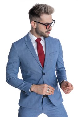 Genç, havalı iş adamı beyaz arka planda güneş gözlüğü takıyor ve dramatik davranıyor.
