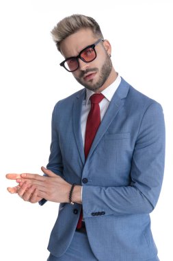 Genç yakışıklı iş adamı avuçlarını ovalıyor ve beyaz arka planda şehvetli oluyor.