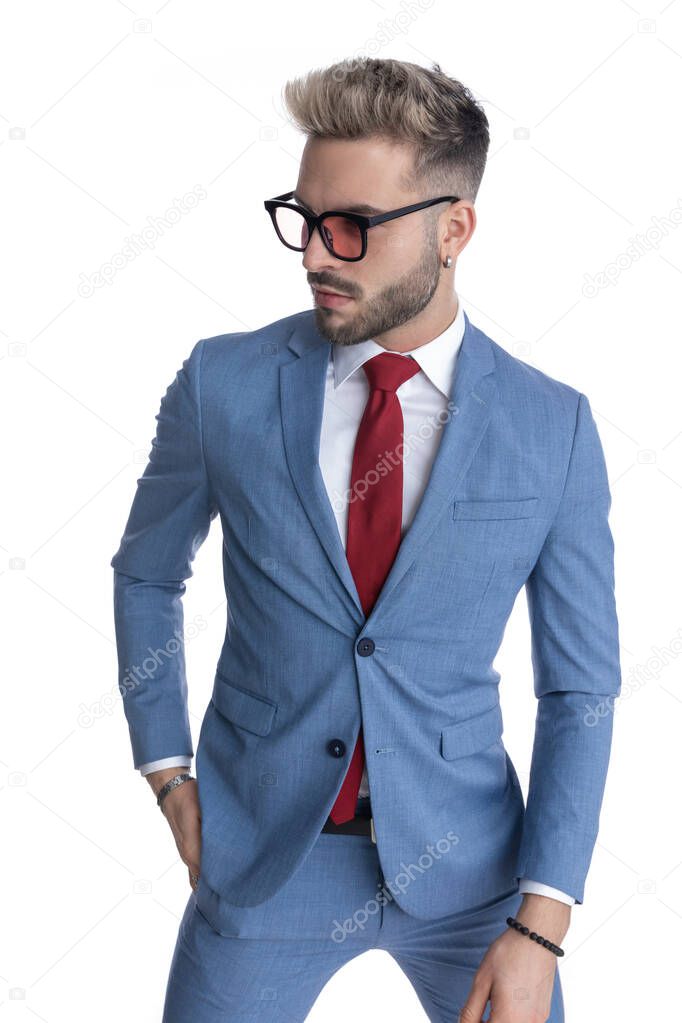 handsome businessman sticking one hand in pocket and looking away with cool attitude