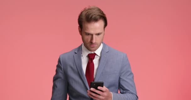 Mavi Takım Elbiseli Elinde Telefon Tutan Mesajlar Okuyan Kaşlarını Çatan — Stok video