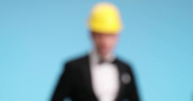 Yakışıklı iş adamı bir şeyi işaret ediyor, sonra kalemini kulağının arkasına alıyor, bir şeyler yazıyor ve onaylıyor.