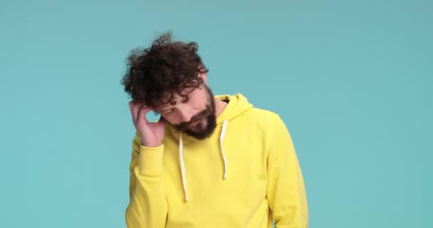 Thoughtful Young Casual Man Yellow Hoodie Holding Hand Forehead Looking — Stock Video