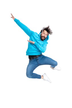 Mavi kapüşonlu, kıvırcık sakallı adam el ele tutuşup havaya zıplıyor. Stüdyoda beyaz arka planda izole bir şekilde eğleniyor ve poz veriyor.