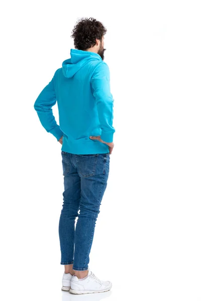 Bebaarde Jongeman Hoodie Hand Hand Heupen Wachtend Rij Witte Achtergrond — Stockfoto