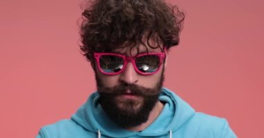 Sıradan bir adam şapkasını ters çevirip ters çeviriyor ve sonra doğru şekilde gülümsüyor.