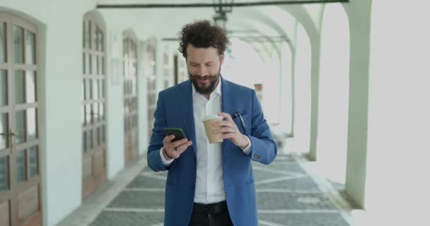 Sexy Curly Cabelo Homem Segurando Telefone Rolagem Verificação Mensagens Beber — Vídeo de Stock