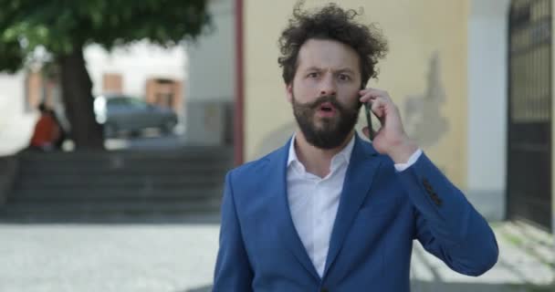 Traşsız Şık Kıyafetli Telefonda Konuşan Sinirli Dışarıda Yürürken Telefonu Kapatan — Stok video