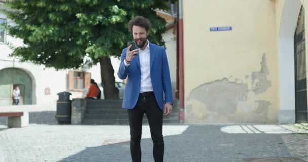 Veselý Mladý Muž Modrým Kabátem Drží Telefon Kontroluje Sociální Média — Stock video