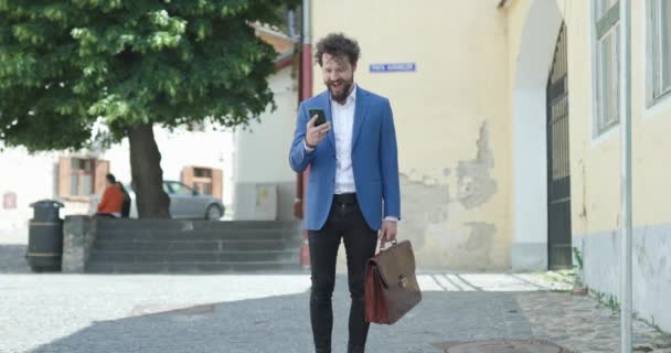 Modelo Moda Casual Inteligente Com Barba Longa Segurando Celular Mala — Vídeo de Stock