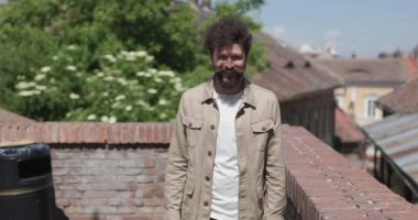 Elinde evrak çantası olan genç bir adam dışarıda başarıyı kutluyor.