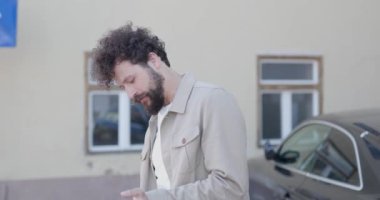 Genç, sıradan bir adam eşyalarını bir çantaya koyuyor ve sonra kameraya gülümsüyor.