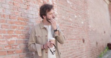 Yakışıklı, sıradan bir adam bıyığını, ceketini takıyor, gözlüklerini takıyor, gözlük takıyor ve kameraya gülümsüyor.