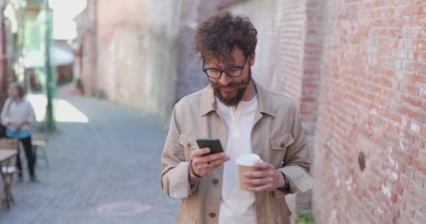 Casual Kerl Kaffee Trinken Brille Tragen Sms Auf Seinem Handy — Stockvideo