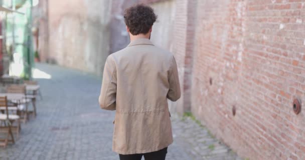 Vista Trasera Hombre Casual Caminando Cerca Una Pared Ladrillo Bebiendo — Vídeos de Stock