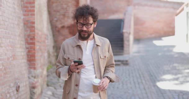 Sexy Dorywczy Mężczyzna Rozgląda Się Wokoło Trzymając Telefon Filiżankę Kawy — Wideo stockowe