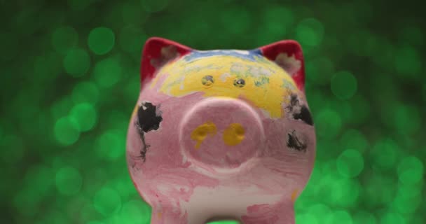 Grüne Lichter Hintergrund Präsentiert Bunt Bemaltes Sparschwein Einem Projektvideo Während — Stockvideo