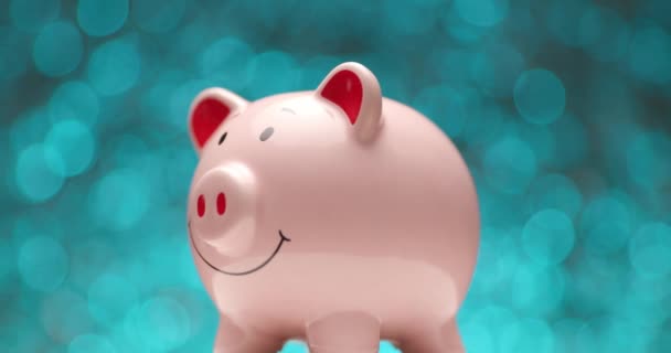 Zijaanzicht Van Roze Spaarvarken Bank Voorkant Van Blauwe Lichten Achtergrond — Stockvideo