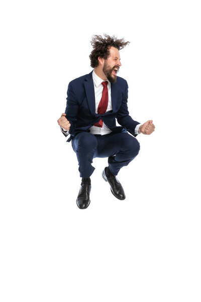 attractive businessman jumping, celebrating succes and looking to the side on white background