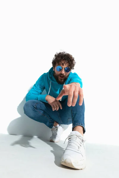 Attractive Casual Guy Cool Style Pointing Camera While Squatting White — Stock Photo, Image