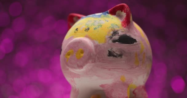 Banco Piggy Pintado Girando Para Lado Fundo Roxo — Vídeo de Stock