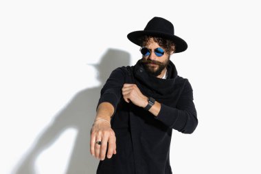 Havalı sıradan bir adam beyaz arka planda güneş gözlüğü takıyor.