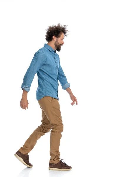 白い背景を背景に歩いている若いカジュアルな男の — ストック写真