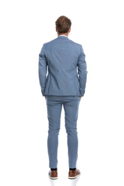 Mavi takım elbiseli zarif iş adamının arka planda el ele tutuşup stüdyoda beyaz arka planda poz vermesi.