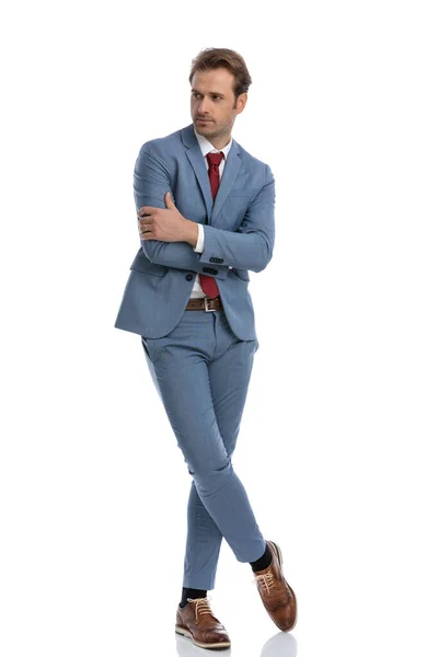 Sexy Elegancki Młody Człowiek Niebieski Garnitur Skrzyżowanie Ramiona Patrząc Bok — Zdjęcie stockowe