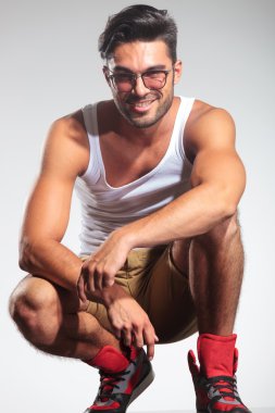 mutlu çömelmiş casual adam gülümsüyor 