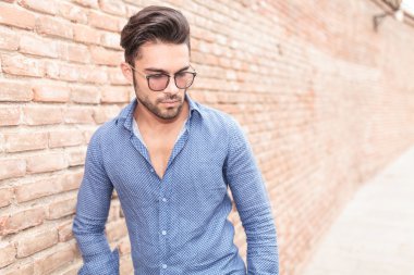 Gözlüklü genç casual adam aşağı görünüyor