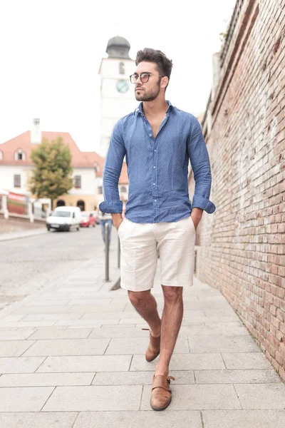 Young casual man walking and looks to side — Stock Photo, Image