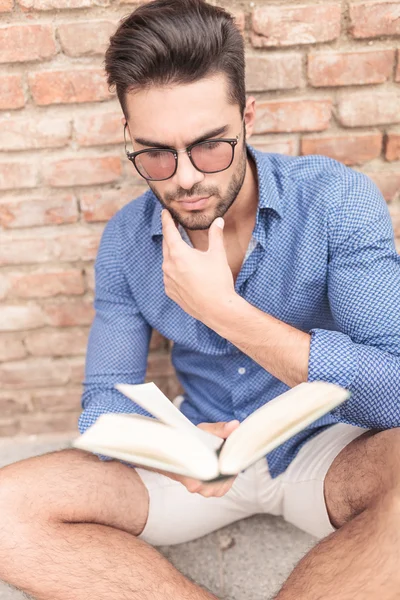 Homem querendo saber sobre o fim do livro que ele lê — Fotografia de Stock