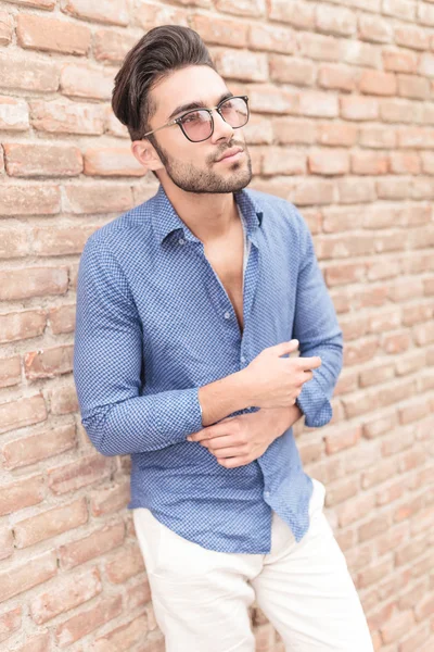 Young casual man near brick wall looking up — Stock Photo, Image