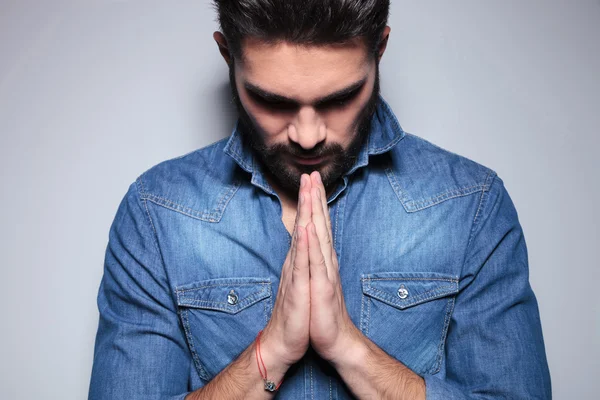 Man in blue shirt praying — Stock Photo, Image