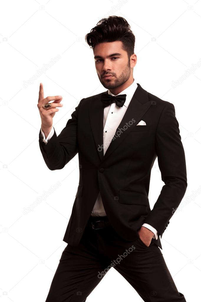 Imposing fashion man in tuxedo snapping his fingers