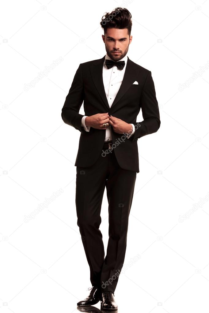 Elegant man in tuxedo unbuttoning his coat