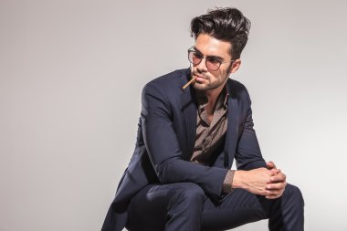 tarafa bakıyor ağzında sigara ile iş adamı