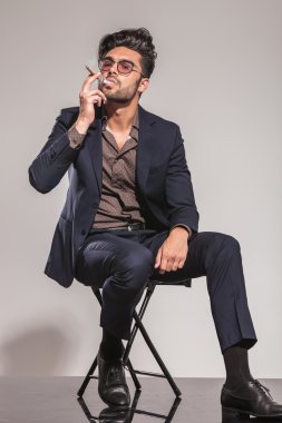 cool adam sigarasını oturma sırasında tadını çıkarıyor. 