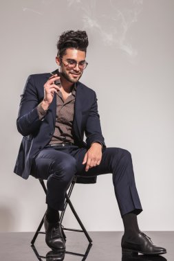 genç adam Sigara İçilmeyen takım elbise ve görünüm aşağı oturmuş