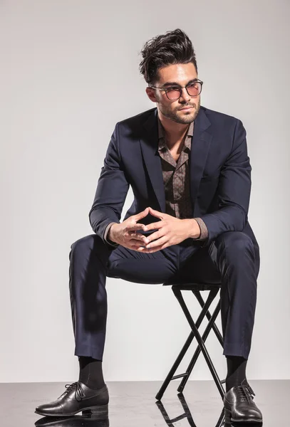 Fashion man in suit sitting and looks to  side — Stock Photo, Image