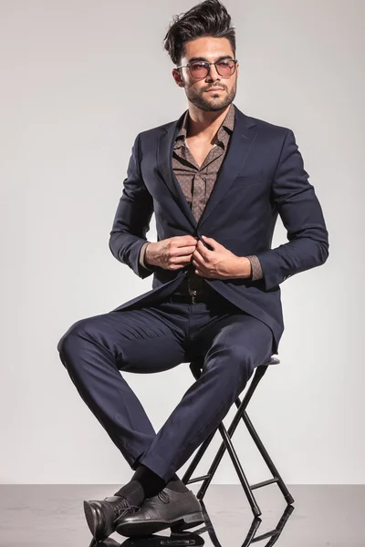 Elegancki mężczyzna zamknięcie jego płaszcz w pozycji siedzącej — Zdjęcie stockowe