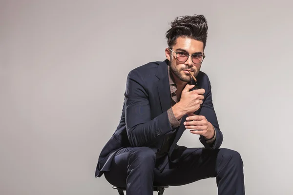 Hombre de moda con gafas encendiendo su cigarrillo — Foto de Stock