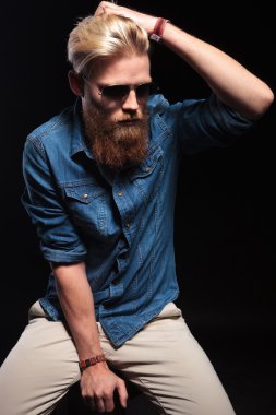 moda adam oturmuş ve saçları sabitleme. 