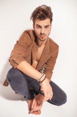 yakışıklı adam tek ayak üstünde oturuyor