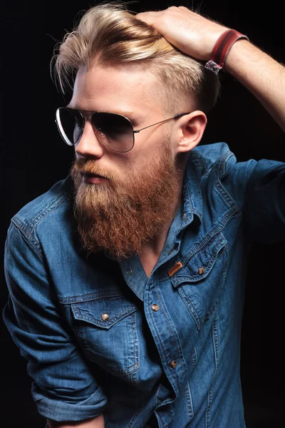 Hombre con barba roja fijándose el pelo y mirando hacia otro lado — Foto de Stock