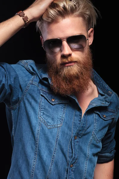 Uomo con lunga barba rossa che indossa occhiali da sole, fissando i capelli — Foto Stock