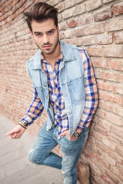 Man leaning on a wall with one hand in pocket — Stock Photo, Image