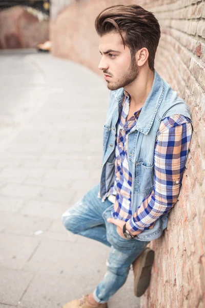 Hombre casual apoyado en un wal de ladrillo — Foto de Stock