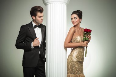 Young elegant couple looking at each other near column clipart